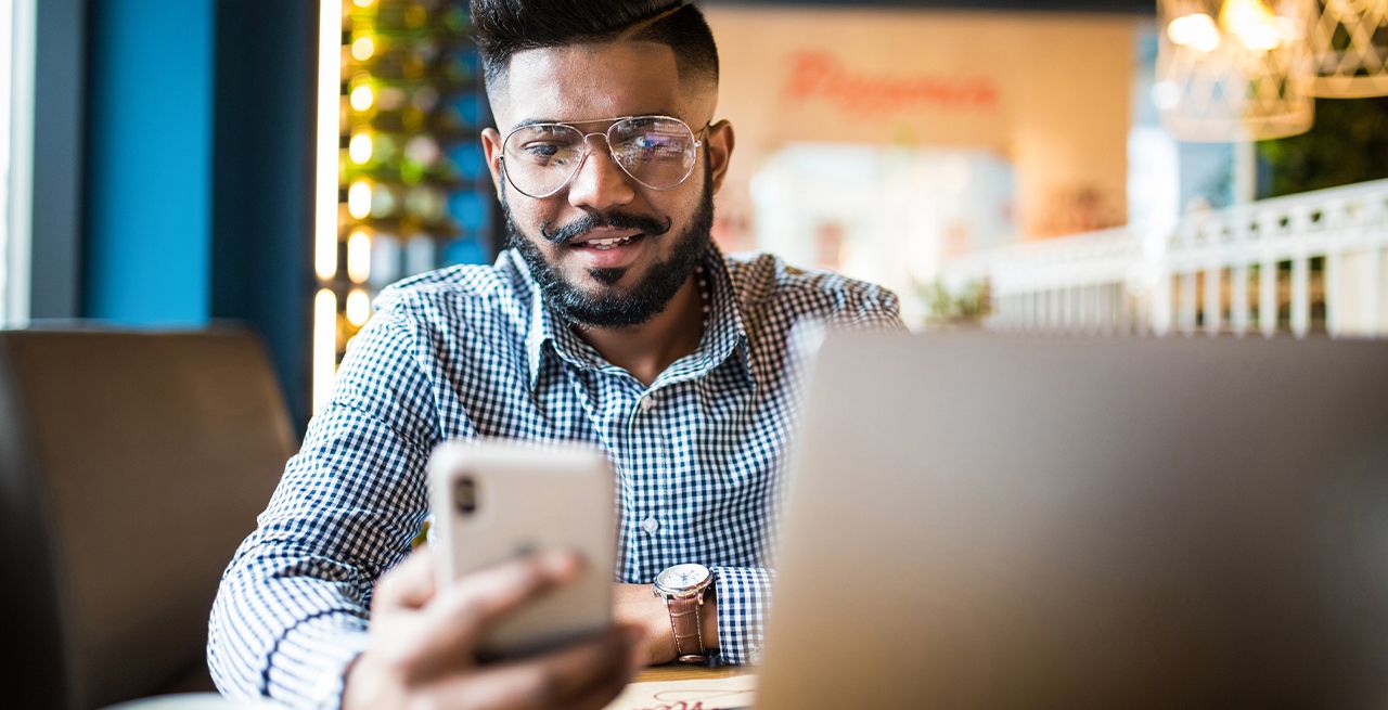 Man on two devices at shop